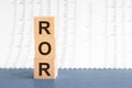 ROR - Rate Of Return. Wooden blocks with the word ROR, yellow bacground. Concept image of Accounting Business Acronym ROR Rate Of