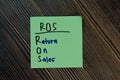 ROS - Return On Sales write on sticky notes isolated on Wooden Table