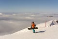 Rosa Khutor, Russia March 20, 2020. A snowboarder walks along the track on rose Peak above the clouds