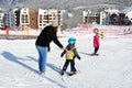 Rosa Khutor, Sochi, Russia, January, 26, 2018. Woman and little boy skiing on the child`s training slope in the background of Oly