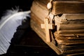Rosary on the background of books and a bird`s feather Royalty Free Stock Photo