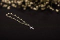 Rosary beads with blurred white small flowers, black background Royalty Free Stock Photo