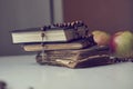 The rosary beads on Catholic Church liturgy books and apples behind them. Royalty Free Stock Photo