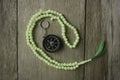 Rosary beads and compass on wooden background Royalty Free Stock Photo