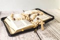 Rosary beads and crucifix cross on holy bible with candles in church Royalty Free Stock Photo