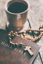 Rosary beads, holy bible and cup of wine. Royalty Free Stock Photo