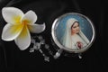 Rosary beads with Jesus Christ holy cross crucifix and the round metal rosary box with portrait of Mother Virgin Marry.