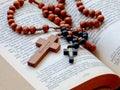 Rosary beads on opened holy Bible