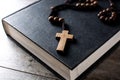 Rosary catholic cross on holy Bible on wooden table Royalty Free Stock Photo