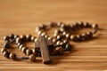 The Rosary. Close up of wooden rosary beads with Jesus Christ holy cross crucifix on the table in brown color background.