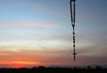 Rosary hanging on colorful sunset sky background. Rosary beads with Jesus Christ holy cross crucifix. Praying rosary concept.