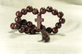 Rosary made of dark wood on a background of cotton fabric