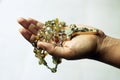 Rosary in one hand. Young junior lady holding rosary with open hand. Female hands holding a rosary with Jesus Christ Cross or Royalty Free Stock Photo