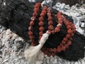 Rosary prayer beads on the ash cinder background. Rudraksha. Mala. Mantra. 108 beads.