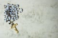Antique rosary on marbled paper background