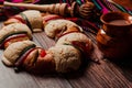 Rosca de reyes or Epiphany cake and clay mug of mexican hot chocolate on a wooden table in Mexico Latin America