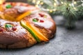 Rosca de reyes, spanish three kings cake eaten on epiphany day, on a gray rustic table