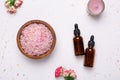 Rose bath salt and natural oil bottles on white background Royalty Free Stock Photo