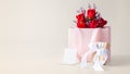 Rose bouquet in paper bag with gift box and card on beige background Royalty Free Stock Photo