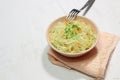 Rose bowl of vegetable marinated cabbage with carrot, fork on green cover on white background