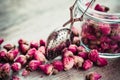 Rose buds tea, tea infuser and glass jar. Royalty Free Stock Photo