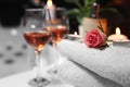 Rose and burning candle on towel near glasses of wine, closeup. Romantic bath Royalty Free Stock Photo