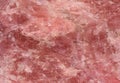 Rose quartz texture - closeup of a rough rose quartz stone surface structure for backgrounds