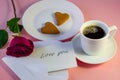 A rose, a cup of coffee, a note, cookies in the shape of a heart on Valentine`s Day. Pink background Royalty Free Stock Photo