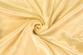 Drapery of golden satin. Luxury smooth yellow golden silk for background. Fabric rose on the drapery Royalty Free Stock Photo