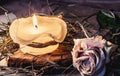 Rose, dry hay and a candle on a table Royalty Free Stock Photo
