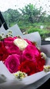 The rose flower basket was photographed in front of the wet windshield of the car after being washed down by the rain Royalty Free Stock Photo