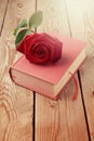 Rose flower on book over wooden background Royalty Free Stock Photo