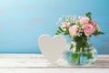 Rose flower bouquet in glass vase and heart shape sign Royalty Free Stock Photo