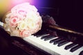 Rose flower in bouquet on keyboard of piano with light flare