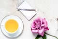 Rose Flower with cup of tea and note pad pen on Marble.   Relaxing Top View with Copy Space Royalty Free Stock Photo