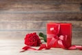 Rose flower and gift box on wooden rustic table. Mother or Valentines day greeting card. Copy space for text. Royalty Free Stock Photo