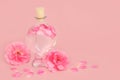 Rose Flower Perfume in Heart Shaped Bottle with Pink Roses Royalty Free Stock Photo