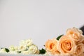 Rose flowers on the edge of a white wooden table