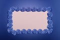 Rose flowers frame on blue background with blank space for text. Holiday concept. Copy space Royalty Free Stock Photo