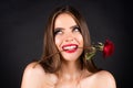 Rose flowers in a womans mouth. Red lips and rose. Beauty girl with sensual mouth. Sexy woman with red rose in teeth on Royalty Free Stock Photo