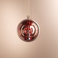 Rose-gold Christmas tree ornament in rose-gold glass on rose-gold background