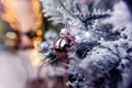 Rose gold pink glass Christmas ball bauble, snowy tree branch, bokeh bg Royalty Free Stock Photo