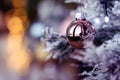 Rose gold pink glass Christmas ball bauble, snowy tree branch, bokeh bg Royalty Free Stock Photo