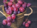 Rose grapes in wooden bucket on a woden table