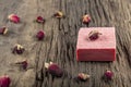 Natural hand made soap with dry pink roses on vintage wooden board. Spa