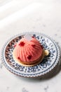 Rose and Lychee Mousses Cake decorated with rose petals in blue and white porcelain plate on marble top table Royalty Free Stock Photo