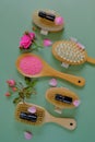 Rose oil. Spa, massage and aromatherapy. Massage brushes set, oil in glass bottles and pink rose flowers on a green Royalty Free Stock Photo