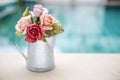 Rose paper in tin water pot with space on blurred blue background Royalty Free Stock Photo