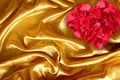 Rose petals on golden brown fabric silk Royalty Free Stock Photo