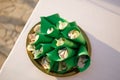 Rose petals lie in folded sheets of paper on a plate